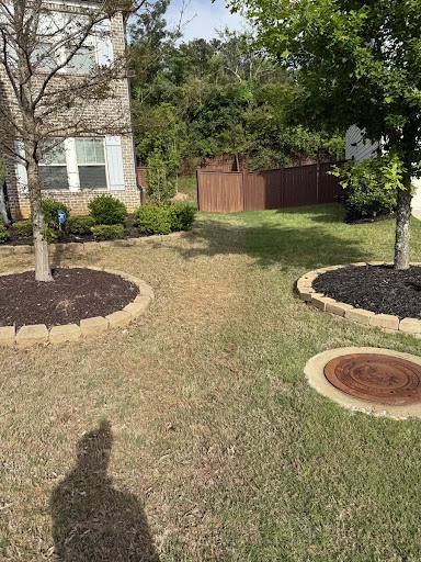 Landscaped front yard with fresh mulch beds and stone edging.